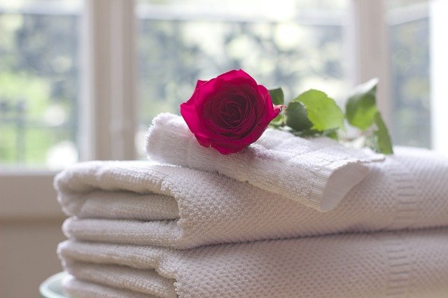 Frisch gewaschene weiße Handtücher rote Rose